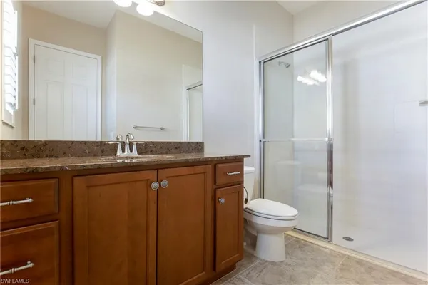 a bathroom with a granite countertop sink toilet and shower