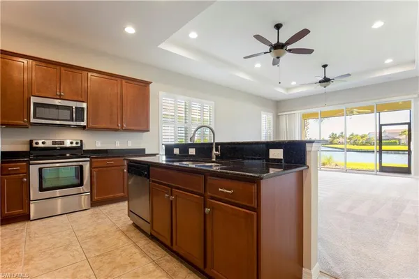 a kitchen with stainless steel appliances granite countertop a stove a sink and a microwave