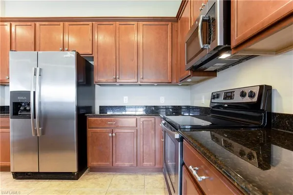 a kitchen with stainless steel appliances granite countertop a stove a refrigerator and a microwave