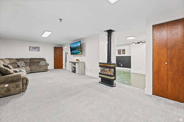 822 Pinewood Circle Price, UT 84501 - Photo 18 of 49 Spacious carpeted room featuring a freestanding fireplace with a black and gold finish, and recessed lighting