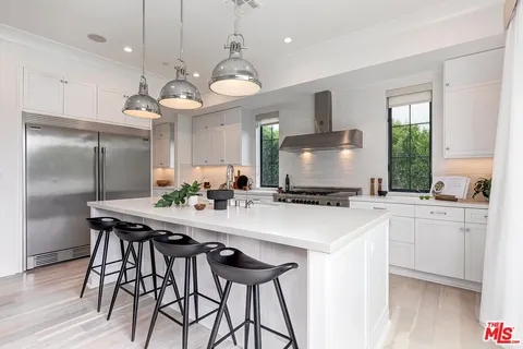 a kitchen with stainless steel appliances a sink stove and cabinets