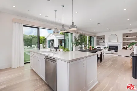 a living room with furniture potted plant and a large window