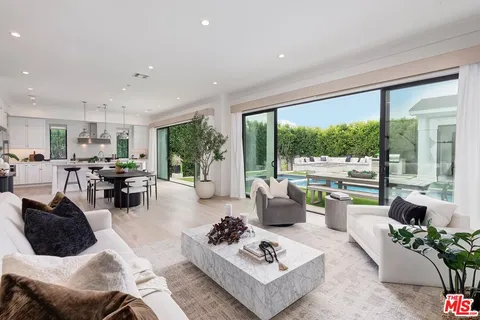 a living room with furniture fireplace and a large window