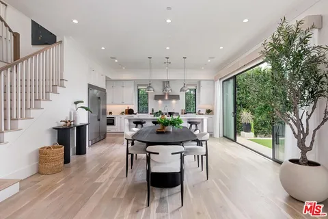 a view of a dining room with furniture a fireplace and wooden floor
