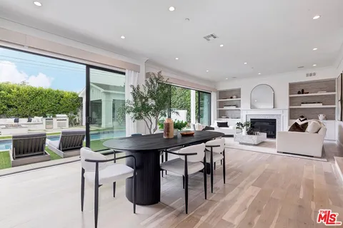 a kitchen with stainless steel appliances a table and chairs in it