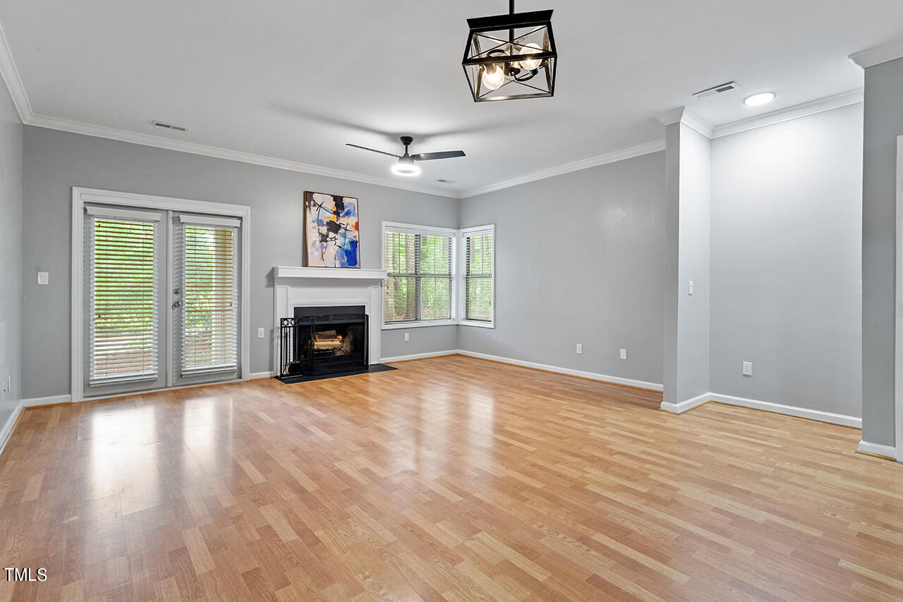 6011 Winterpointe Lane, Unit 104 Raleigh, NC 27606 - Photo 12 of 31 a view of an empty room with wooden floor fireplace and a window