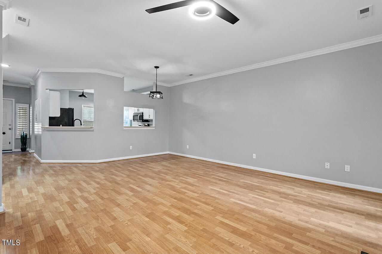6011 Winterpointe Lane, Unit 104 Raleigh, NC 27606 - Photo 13 of 31 an empty room with chandelier fan and windows