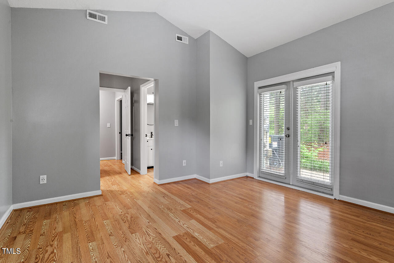 6011 Winterpointe Lane, Unit 104 Raleigh, NC 27606 - Photo 20 of 31 an empty room with wooden floor and windows