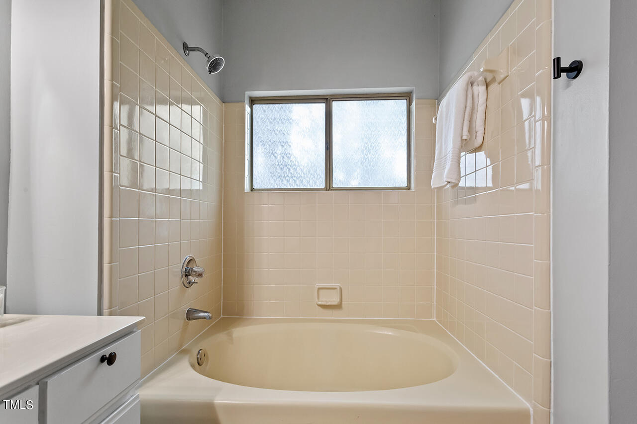 6011 Winterpointe Lane, Unit 104 Raleigh, NC 27606 - Photo 23 of 31 a white bath tub sitting next to a white sink