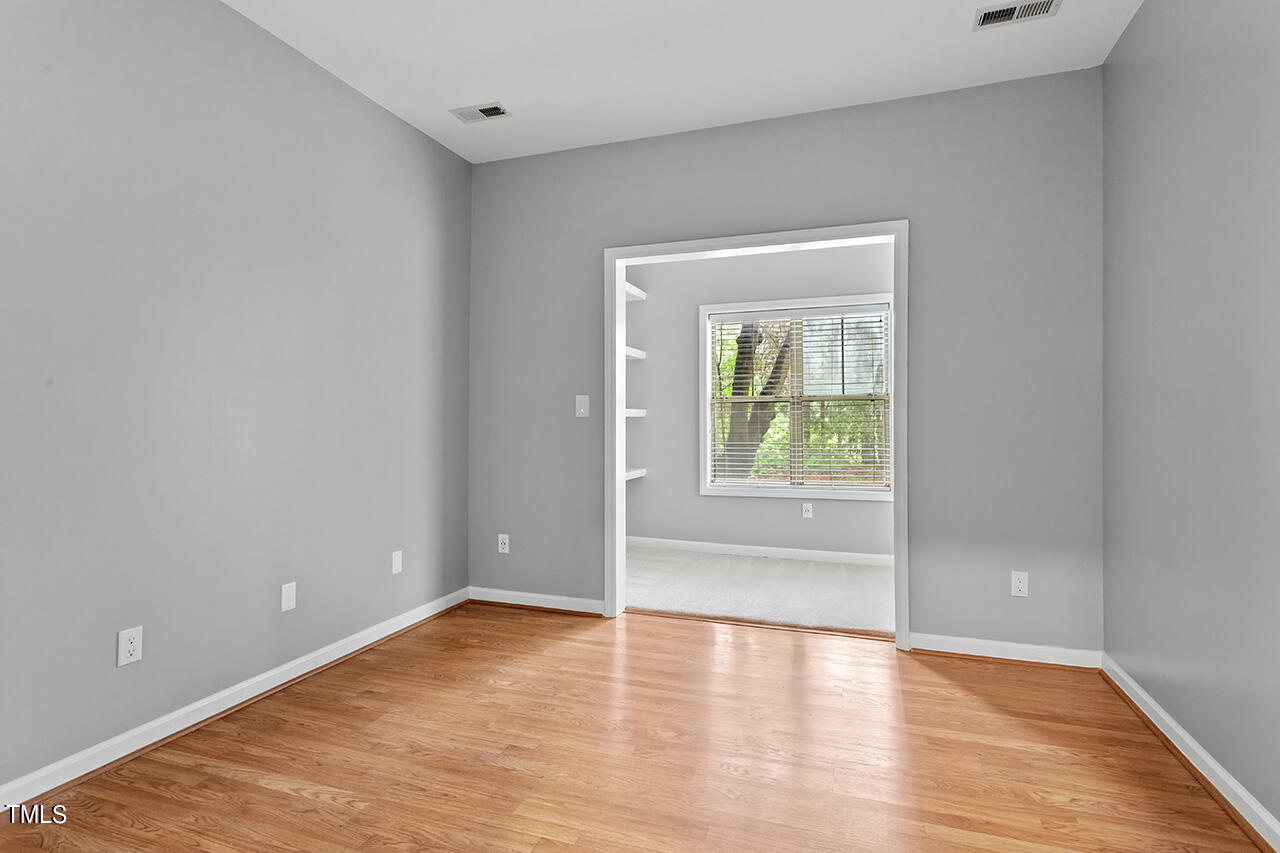 6011 Winterpointe Lane, Unit 104 Raleigh, NC 27606 - Photo 24 of 31 a view of an empty room with wooden floor and a window