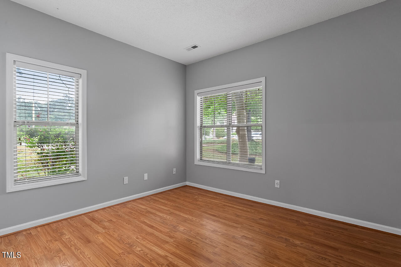 6011 Winterpointe Lane, Unit 104 Raleigh, NC 27606 - Photo 26 of 31 a view of an empty room with wooden floor and a window