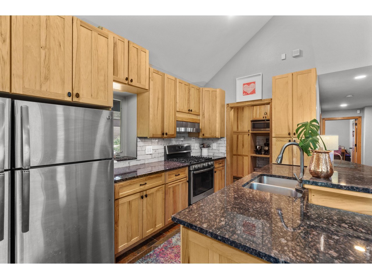 187 Lynx Drive Ward, CO 80481 - Photo 11 of 50 a kitchen with kitchen island granite countertop a refrigerator a sink a stove and white cabinets