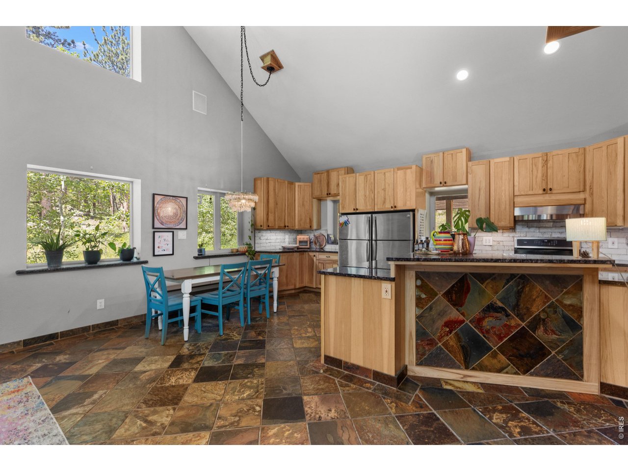 187 Lynx Drive Ward, CO 80481 - Photo 12 of 50 a kitchen with stainless steel appliances a stove a refrigerator a microwave a dining table and chairs