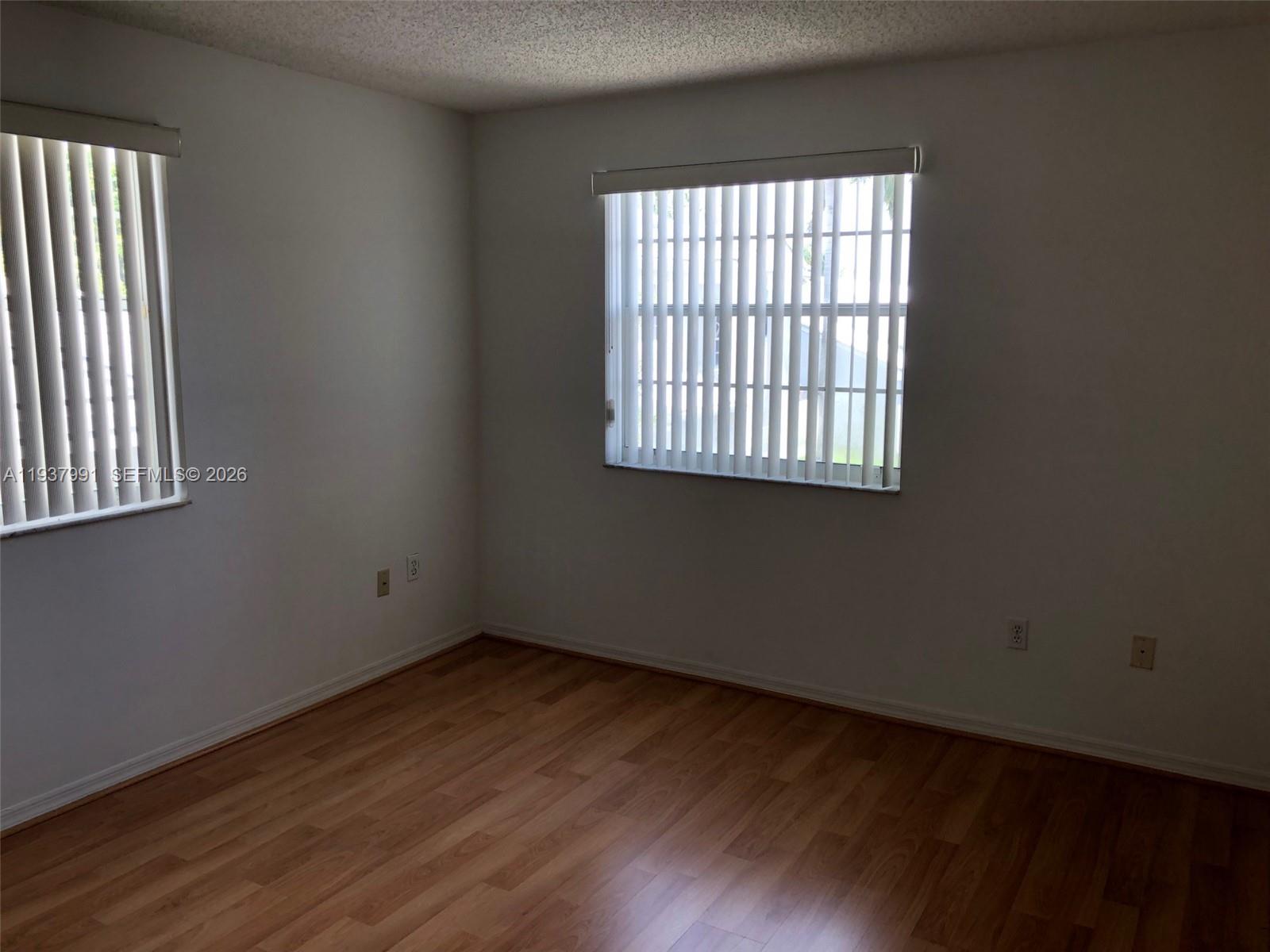 11274 Southwest 64th Lane Miami, FL 33173 - Photo 5 of 34 an empty room with wooden floor and windows