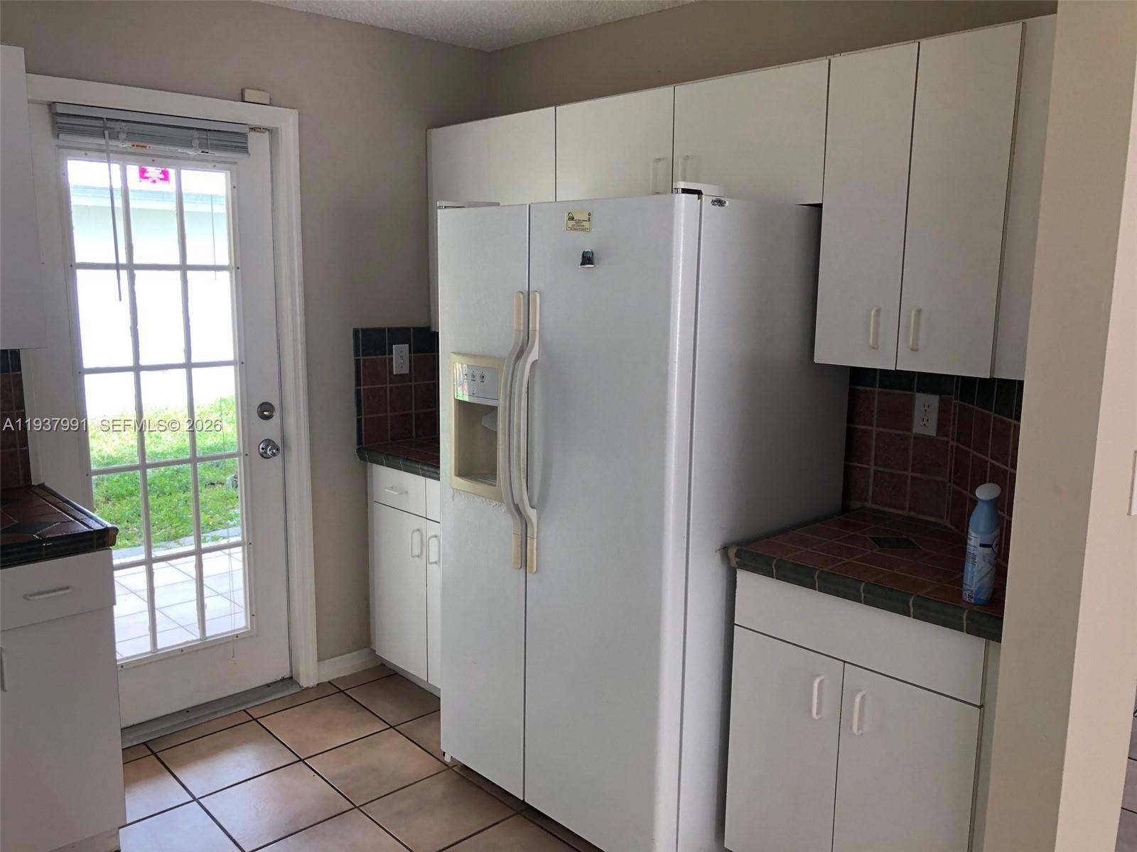11274 Southwest 64th Lane Miami, FL 33173 - Photo 7 of 34 a kitchen with a refrigerator and window