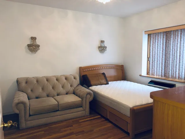 a bedroom with a bed couch and window