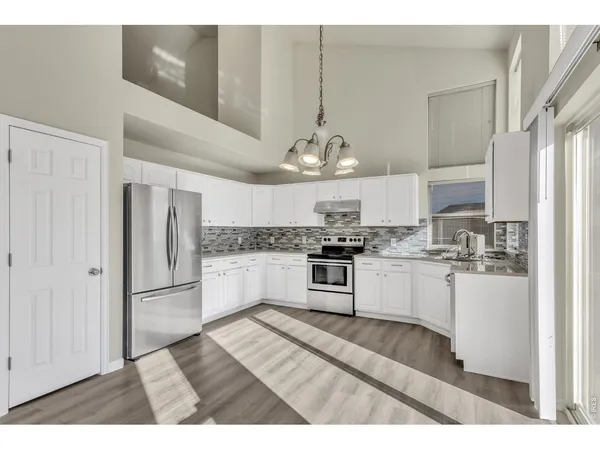 a kitchen with stainless steel appliances kitchen island granite countertop a refrigerator and a sink