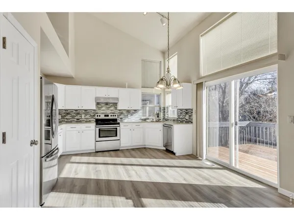 a open kitchen with granite countertop a stove a sink and a refrigerator