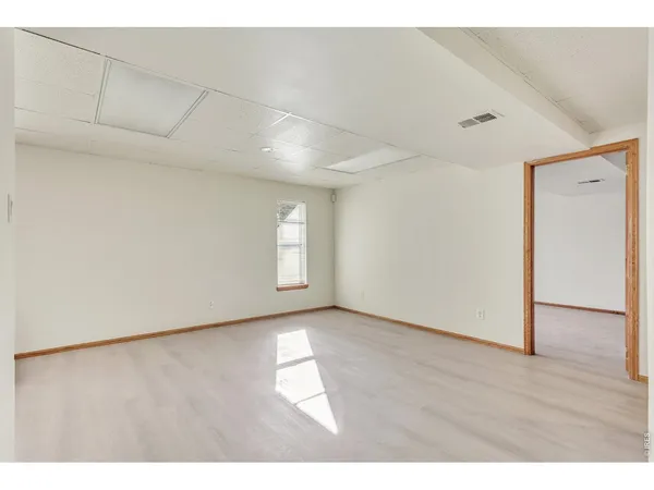 a view of an empty room with wooden floor and staircase