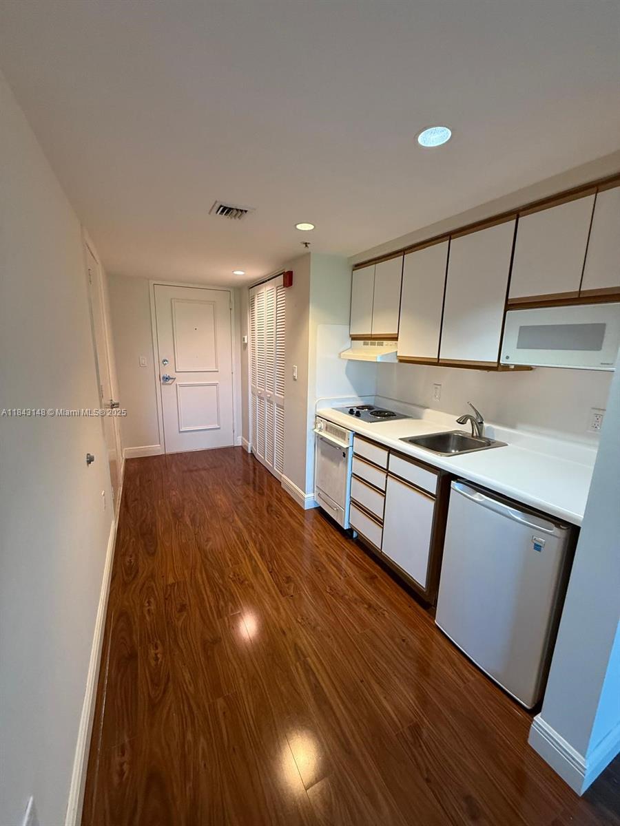 5715 Southwest 72nd Street, Unit 5715 South Miami, FL 33143 - Photo 1 of 6 a kitchen with granite countertop a stove and cabinets
