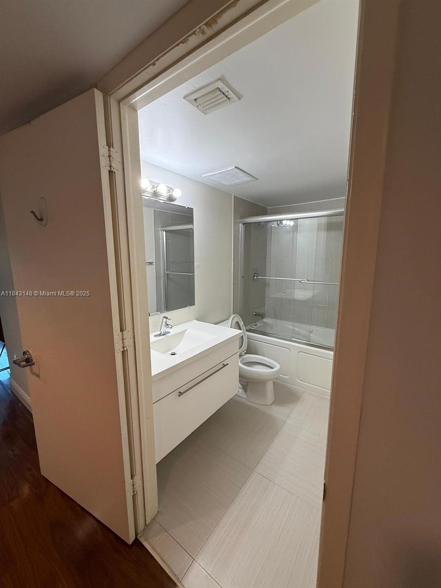 5715 Southwest 72nd Street, Unit 5715 South Miami, FL 33143 - Photo 6 of 6 a bathroom with a tub shower and sink