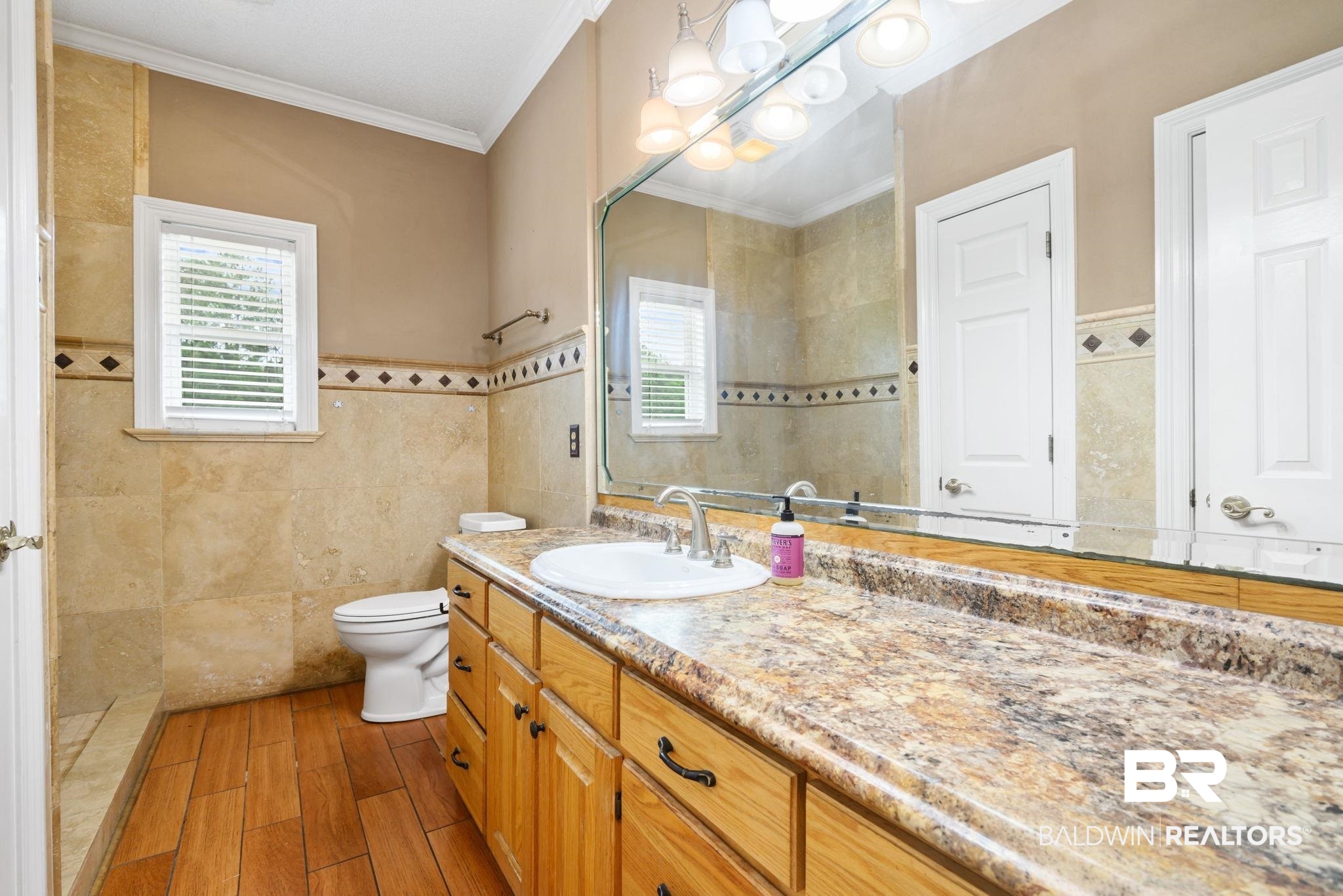 7540 2 Mile Road Irvington, AL 36544 - Photo 50 of 82 Spacious bathroom featuring a large vanity with an integrated sink, a broad mirror with overhead lighting, and extensive wall tiling