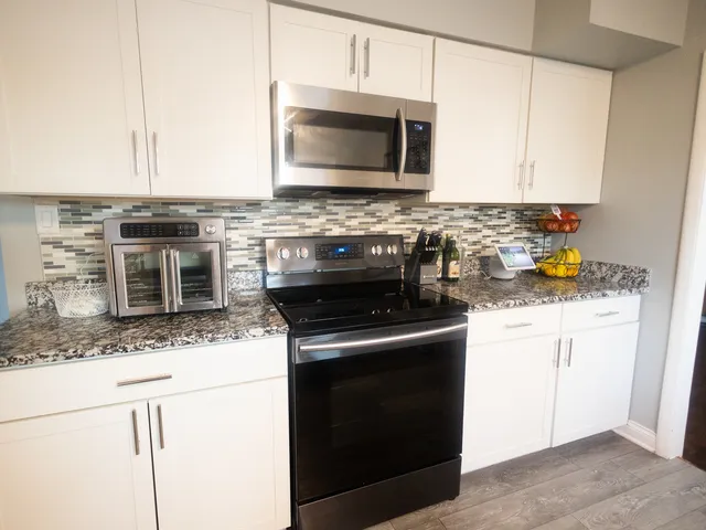 a kitchen with stainless steel appliances granite countertop a stove microwave and oven