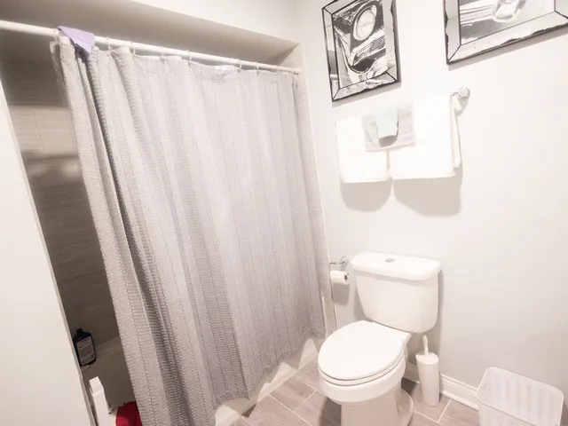 a white toilet sitting next to a small window