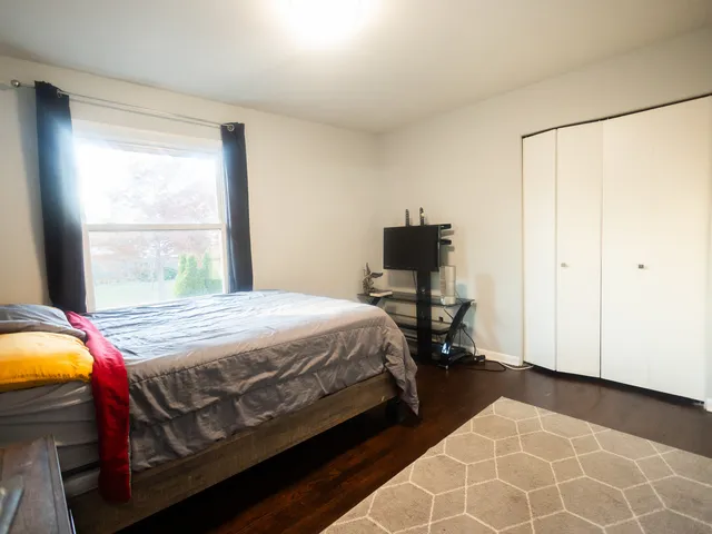 a bedroom with a bed a table and chair