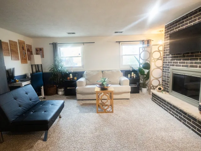 a living room with furniture a flat screen tv and a fireplace