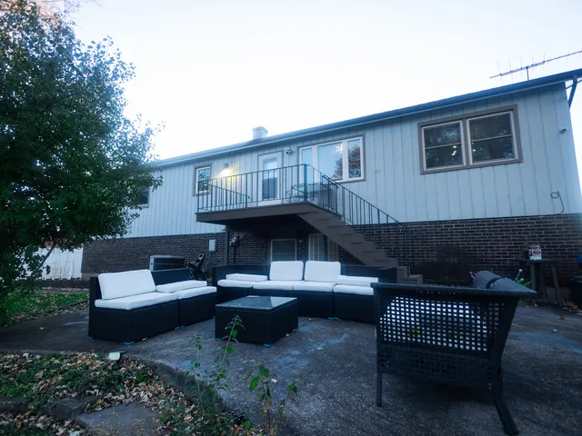 a view of a patio with couches table and chairs and potted plants
