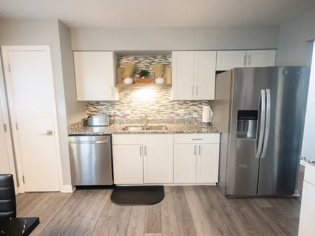a kitchen with stainless steel appliances a refrigerator and wooden floor