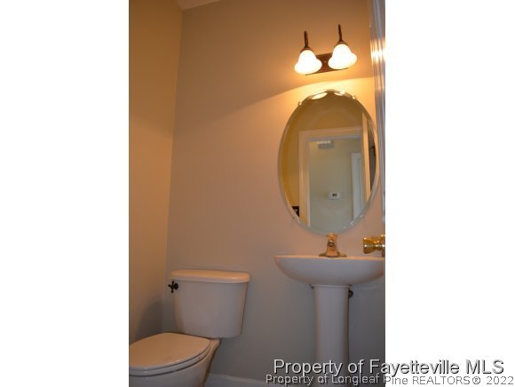 3516 Talus Road Fayetteville, NC 28306 - Photo 8 of 19 a bathroom with a toilet sink and mirror