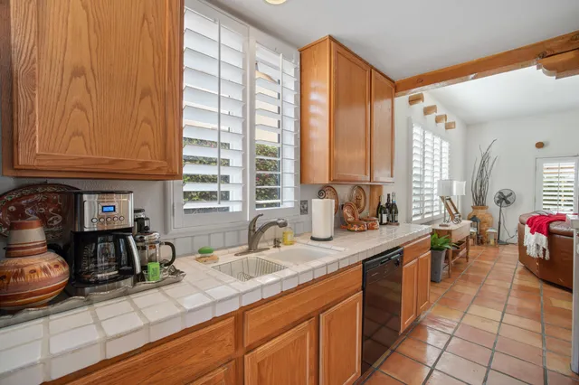 a kitchen with stainless steel appliances kitchen island granite countertop table chairs and a refrigerator