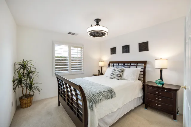 a bedroom with a bed couch and a view of balcony