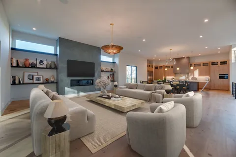 a living room with furniture kitchen view and a flat screen tv