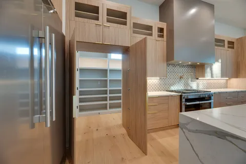 an empty room with kitchen and a fireplace