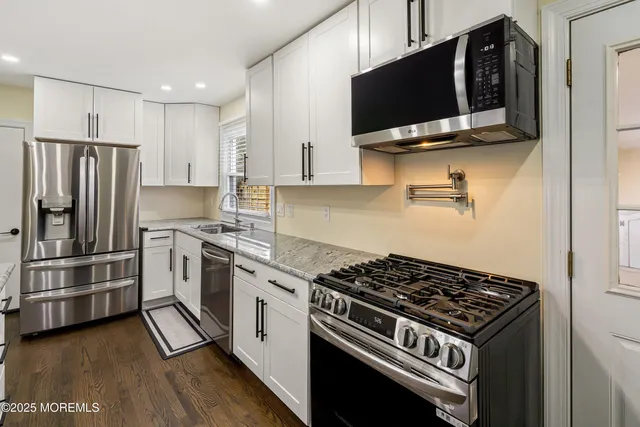 a kitchen with stainless steel appliances a stove a microwave and a refrigerator