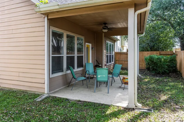 a view of a patio with table and chairs and floor to ceiling window