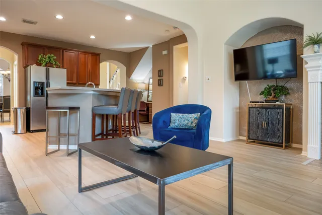 a living room with furniture a flat screen tv and kitchen view