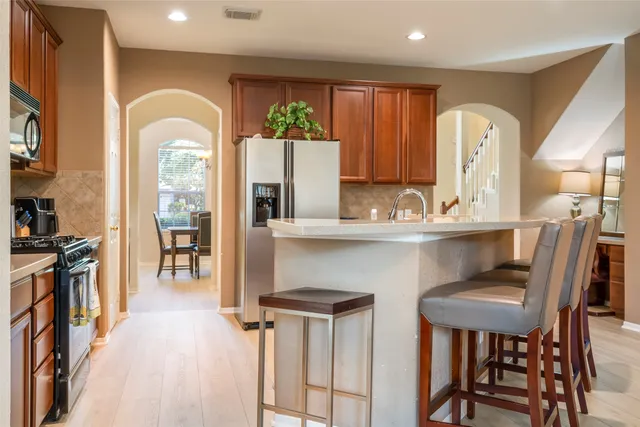 a kitchen with appliances cabinets and chair