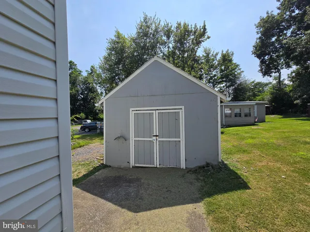 a view of a house with backyard and trees