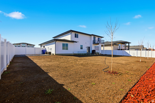 3902 West 825 North West Point, UT 84015 - Photo 35 of 49 Back of property with a fenced backyard and a balcony