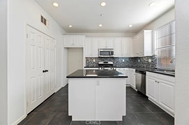 a kitchen with granite countertop a sink stove and cabinets