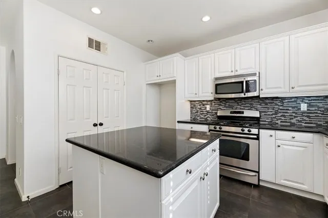 a kitchen with stainless steel appliances granite countertop a sink and a window