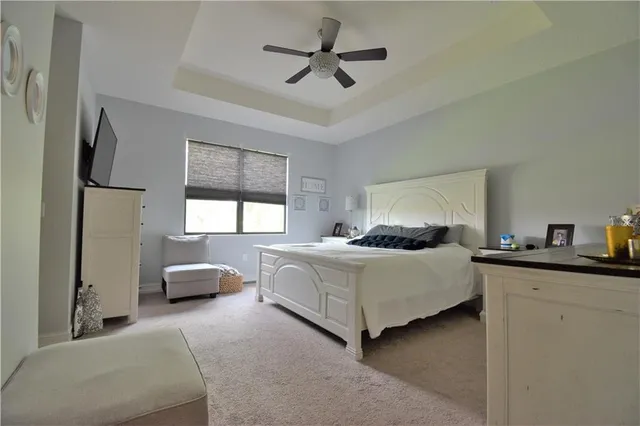 a bedroom with a bed and a flat tv screen on a dresser