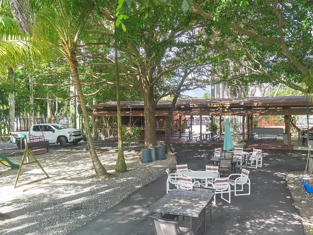 a view of a patio with a table chairs and a grill