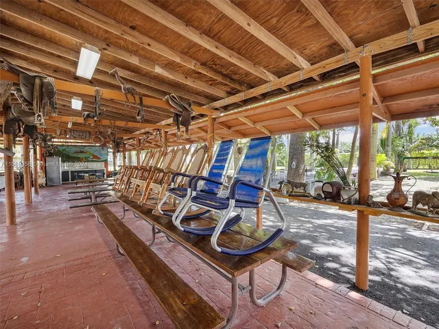 a view of a patio with couches and table and chairs next to a yard
