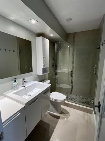a bathroom with a double vanity sink toilet and shower