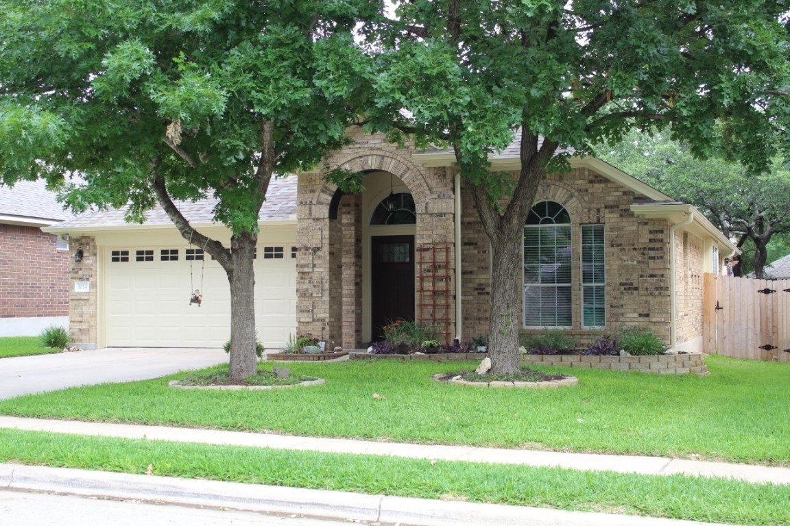 a front view of a house with a garden and yard